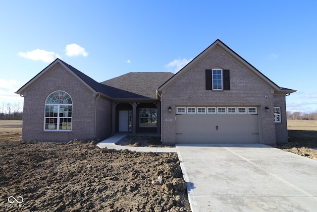 traditional-style house featuring an attached garage, concrete driveway, and brick siding