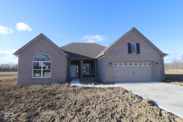 view of front of property with concrete driveway, brick siding, and an attached garage