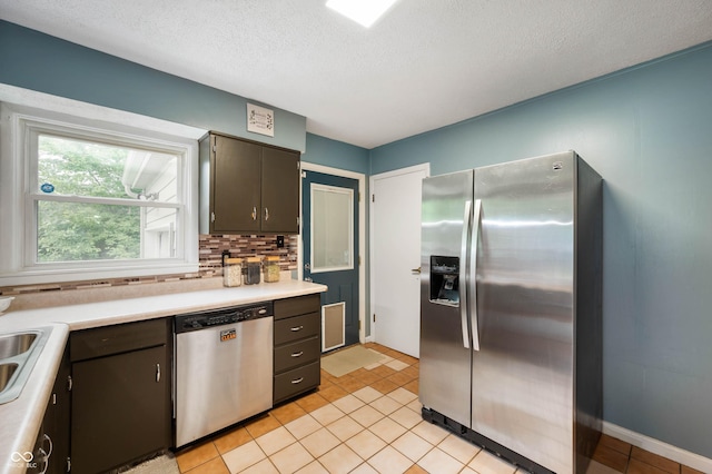 6865 Meadow View Dr, Lawrence, IN 46226 - kitchen with appliances with stainless steel finishes, light countertops, decorative backsplash, a textured ceiling, and light tile patterned floors