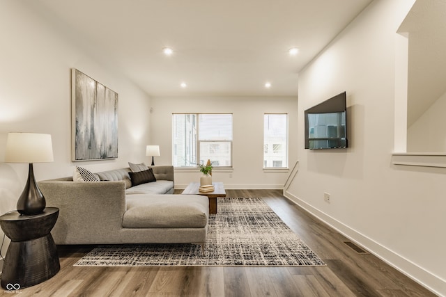 living area with visible vents, baseboards, dark wood-type flooring, and recessed lighting