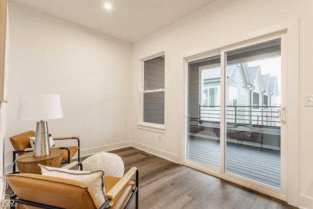 living area with baseboards and wood finished floors