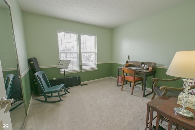 carpeted home office with a textured ceiling and baseboards