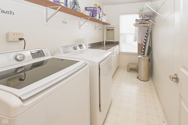 washroom featuring baseboards, separate washer and dryer, light floors, and cabinet space