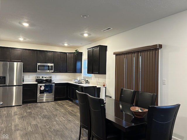 kitchen featuring a textured ceiling, appliances with stainless steel finishes, sink, and hardwood / wood-style flooring