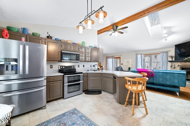 kitchen featuring a breakfast bar, glass insert cabinets, stainless steel appliances, and light countertops