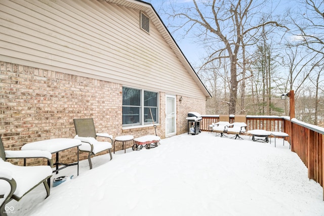 snow covered deck with a grill