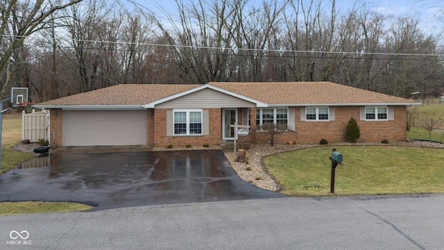 ranch-style house with a garage and a front lawn