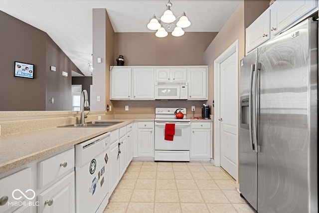 kitchen with light countertops, an inviting chandelier, white cabinets, a sink, and white appliances