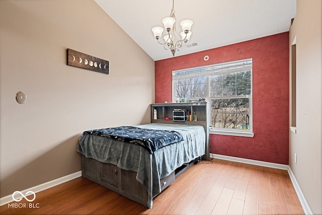 bedroom featuring lofted ceiling, baseboards, and wood finished floors