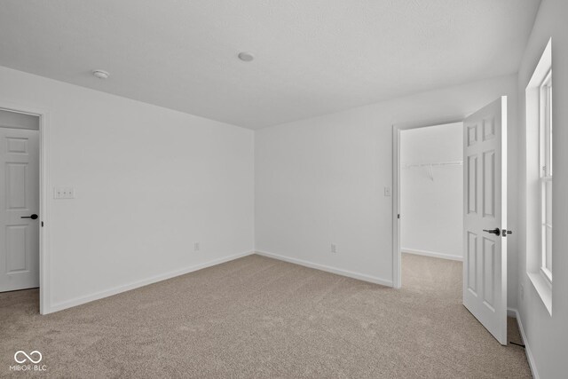5119 Rolling Meadow Blvd, Indianapolis, IN 46237 - unfurnished bedroom with baseboards, a walk in closet, a closet, and carpet flooring