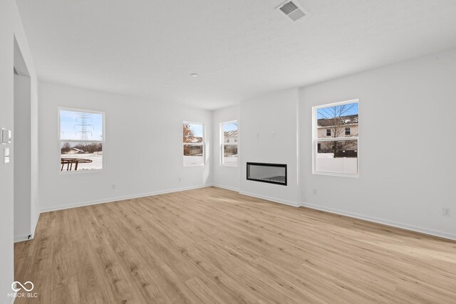 5119 Rolling Meadow Blvd, Indianapolis, IN 46237 - unfurnished living room featuring visible vents, a healthy amount of sunlight, and light wood-type flooring