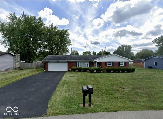 ranch-style house featuring a front yard and a garage