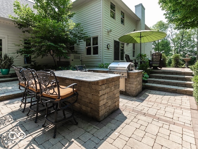 view of patio / terrace featuring a grill, outdoor dry bar, and area for grilling