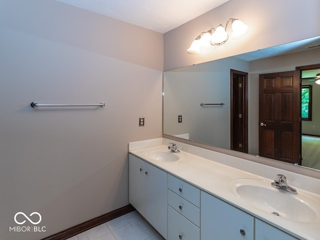 full bathroom with tile patterned floors, a sink, baseboards, and double vanity