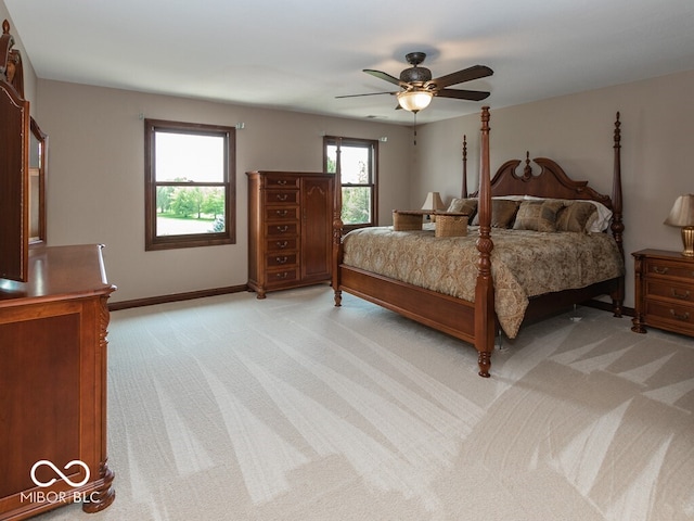 bedroom featuring light colored carpet, ceiling fan, and baseboards