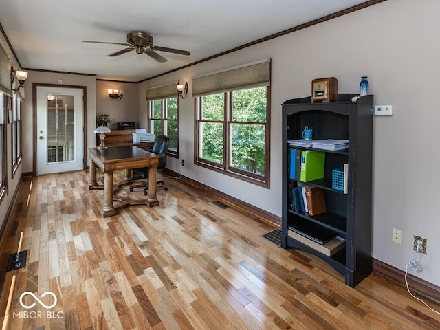 office area featuring visible vents, a ceiling fan, baseboards, ornamental molding, and light wood finished floors