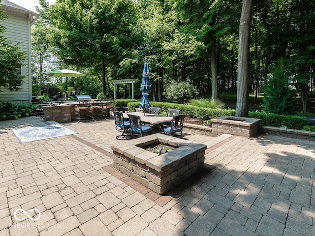 view of patio featuring an outdoor fire pit, outdoor dining space, and a pergola