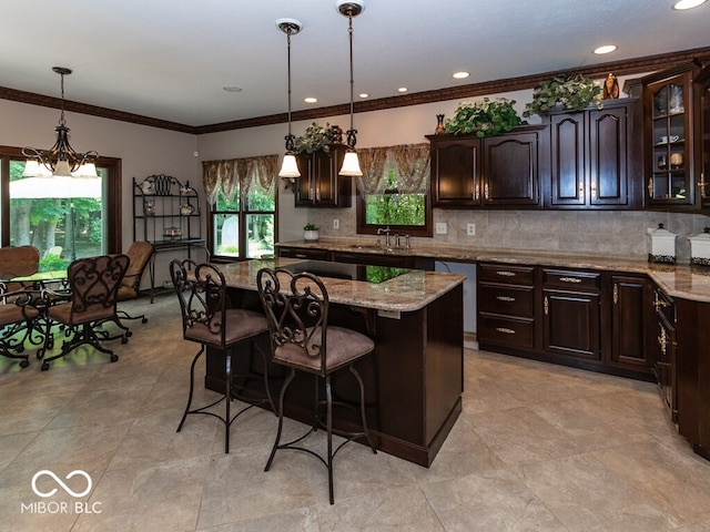 kitchen featuring light stone counters, hanging light fixtures, glass insert cabinets, a kitchen island, and dark brown cabinets