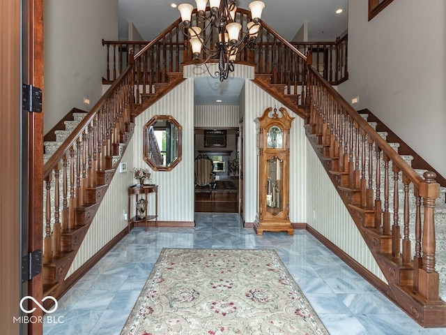 foyer featuring a high ceiling, baseboards, and wallpapered walls