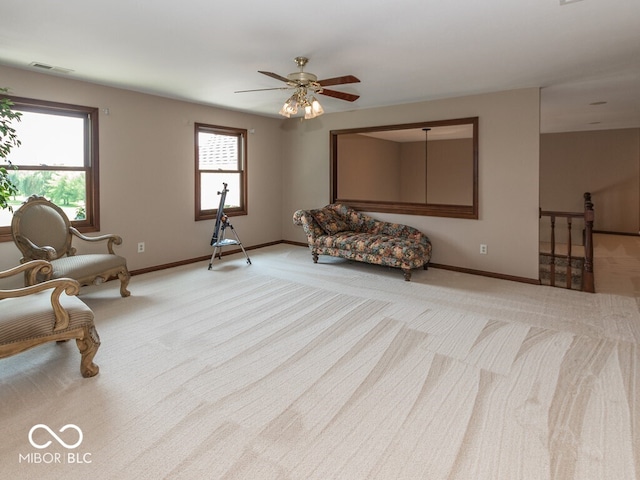 living area with light colored carpet, visible vents, and baseboards