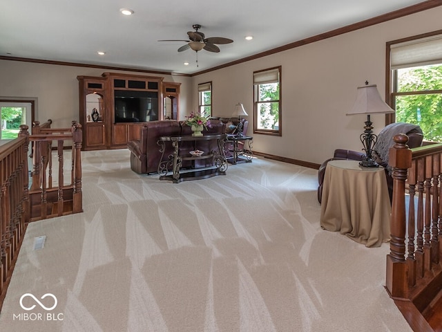 living room with baseboards, ornamental molding, a wealth of natural light, and light colored carpet