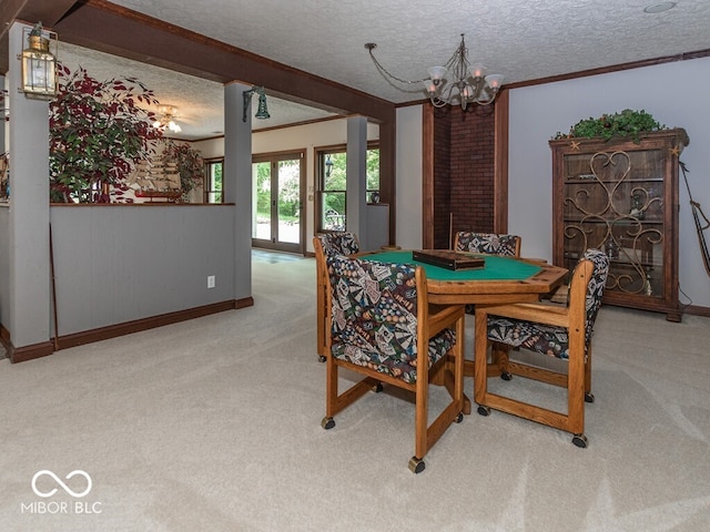 dining area with ornamental molding, light colored carpet, a textured ceiling, and an inviting chandelier