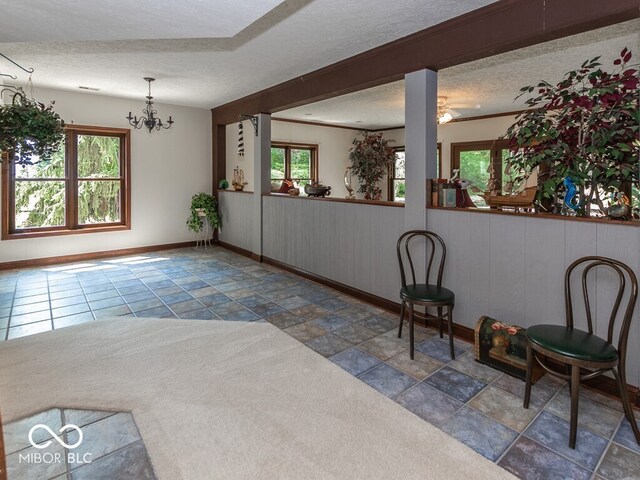 interior space featuring a textured ceiling, baseboards, and an inviting chandelier