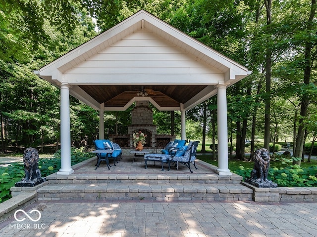 view of patio with an outdoor stone fireplace and a gazebo