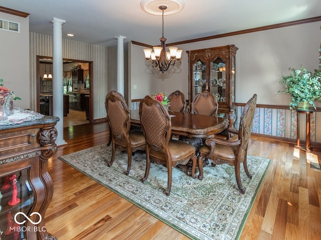 dining area with visible vents, light wood-style floors, ornamental molding, ornate columns, and wallpapered walls