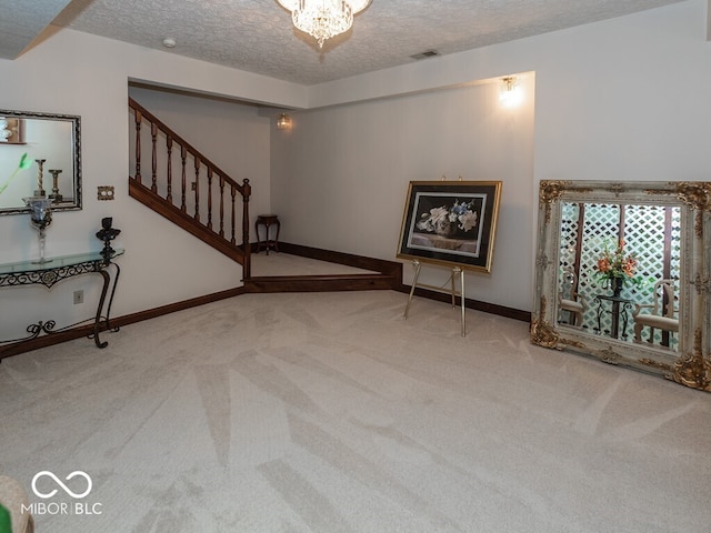 unfurnished living room with visible vents, light colored carpet, a textured ceiling, and stairs