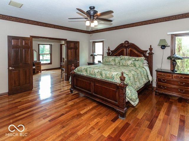 bedroom with dark wood finished floors, visible vents, and baseboards