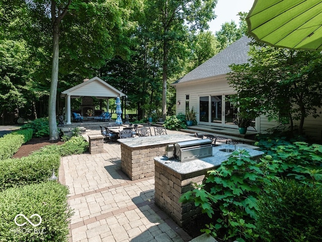 view of patio / terrace featuring area for grilling, a gazebo, an outdoor fire pit, and an outdoor kitchen