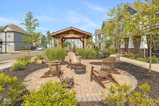 view of patio with a residential view, a fire pit, and a gazebo