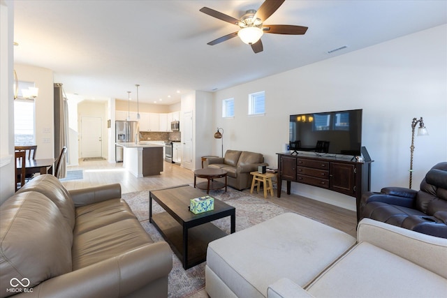 living room with a ceiling fan, recessed lighting, visible vents, and light wood finished floors