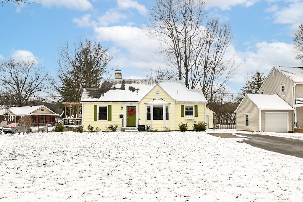 bungalow with a garage and a chimney