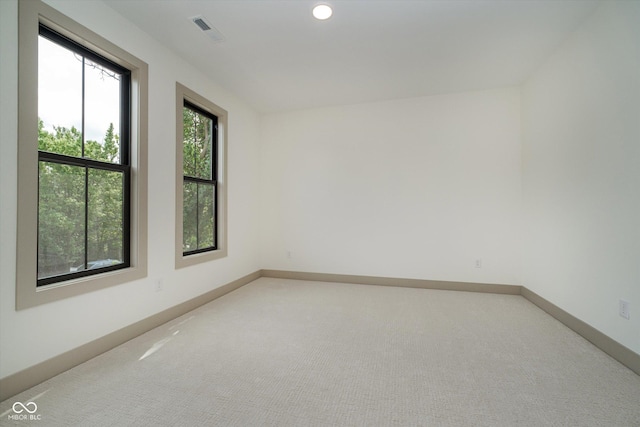 spare room featuring light carpet, baseboards, visible vents, and recessed lighting