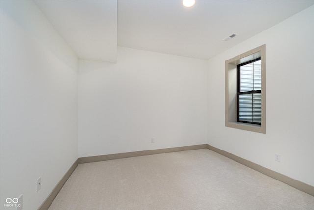 unfurnished room featuring visible vents, light carpet, and baseboards