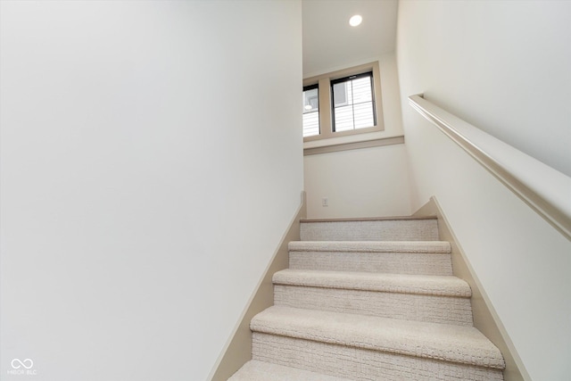 staircase featuring baseboards and recessed lighting