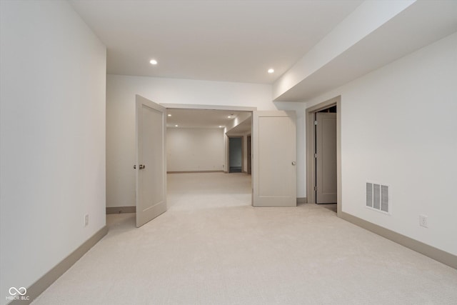 empty room featuring baseboards, recessed lighting, visible vents, and light colored carpet