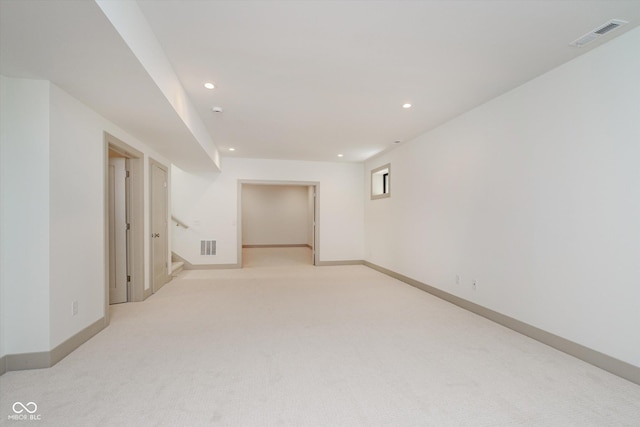 spare room with light carpet, recessed lighting, visible vents, and baseboards