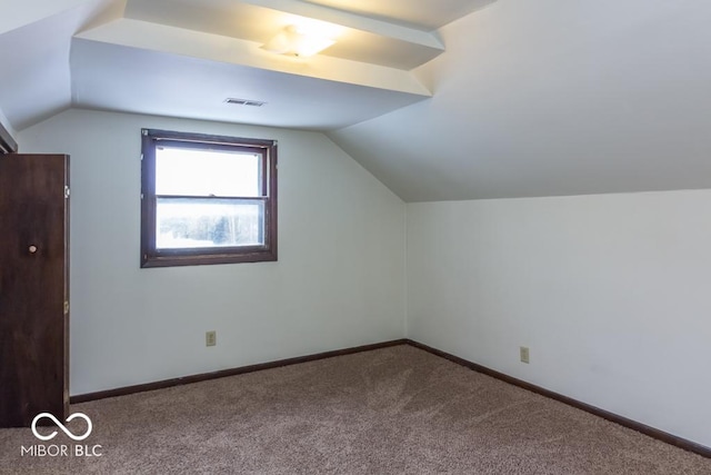 additional living space with lofted ceiling, visible vents, baseboards, and carpet flooring