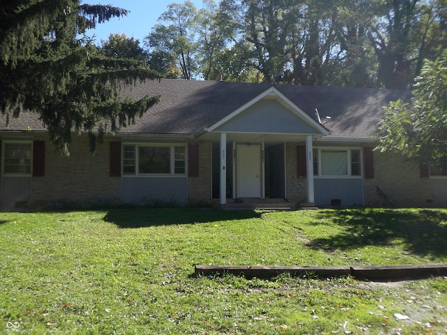 ranch-style home featuring a shingled roof and a front yard