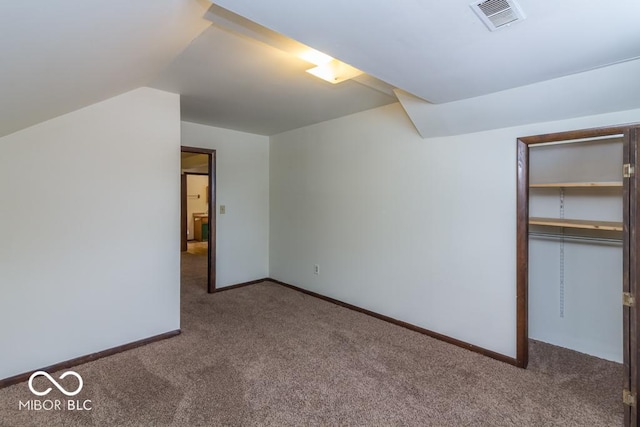 unfurnished bedroom with carpet floors, lofted ceiling, visible vents, and baseboards