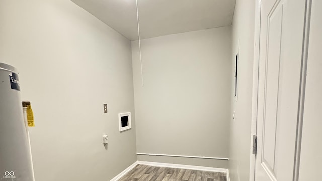 clothes washing area with gas water heater, hookup for a washing machine, laundry area, baseboards, and wood finished floors