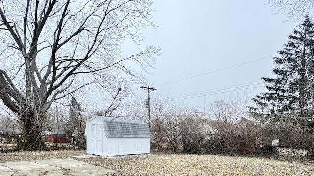 view of yard featuring a storage unit, an outdoor structure, and fence