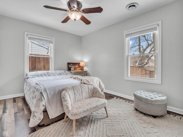 bedroom with baseboards, dark wood finished floors, and a ceiling fan