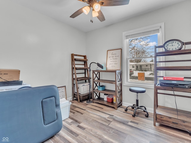 office space featuring light wood-style floors, ceiling fan, and baseboards