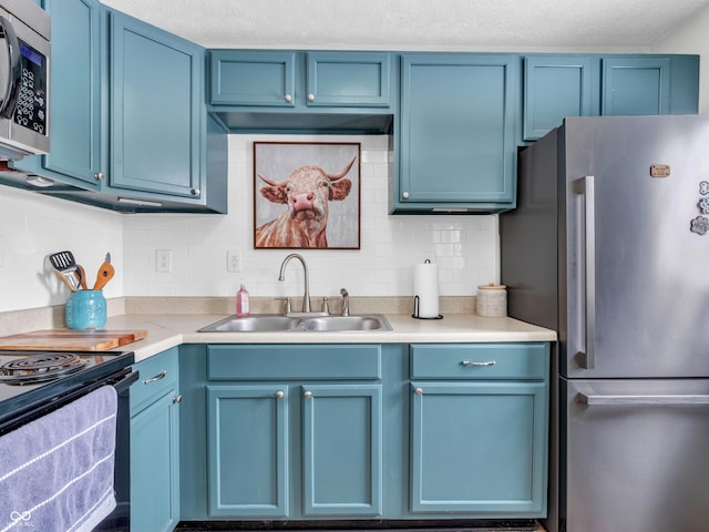 kitchen featuring stainless steel appliances, blue cabinets, light countertops, and a sink