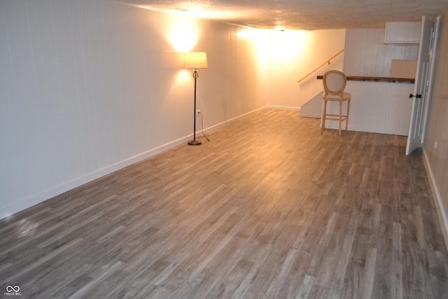 basement featuring a textured ceiling and hardwood / wood-style flooring