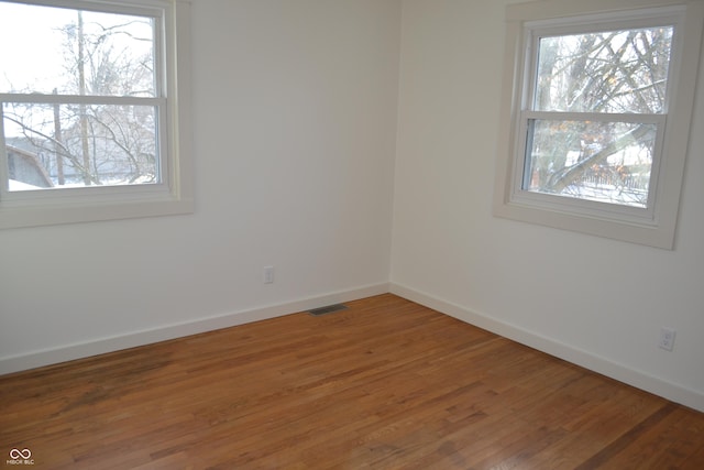 unfurnished room with hardwood / wood-style floors